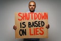 Male protester holding placard against coronavirus lockdowns against grey background Royalty Free Stock Photo