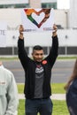 A male protester holds a sign that reads Resist Hate