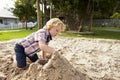 Male Pupil At Montessori School Playing In Sand Pit At Breaktime