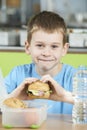 Male Pupil Sitting At Table In School Cafeteria Eating Healthy P Royalty Free Stock Photo