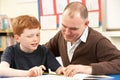 Male Pupil Studying in classroom with teacher Royalty Free Stock Photo