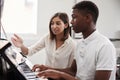 Male Pupil With Teacher Playing Piano In Music Lesson Royalty Free Stock Photo