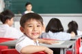 Male Pupil Working At Desk In Chinese School