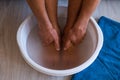 Male put hands and feet in bath with hot water and baking soda at home. Homemade bath soak for dry feet skin