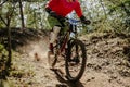 male racer cyclist riding dusty trail downhill race in forest