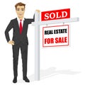 Male real estate agent standing next to a sold for sale sign Royalty Free Stock Photo