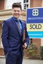 Male Realtor Standing Outside Residential Property With Sold Sign Royalty Free Stock Photo