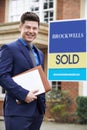 Portrait Of Male Realtor Standing Outside Residential Property With Sold Sig Royalty Free Stock Photo