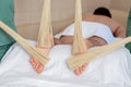 Male receiving feet massage with bamboo brooms