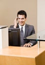 Male receptionist talking on telephone earpiece Royalty Free Stock Photo