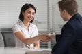 Male recruiter handshake smiling female candidate at interview