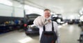 Male repairman holding wrench in car workshop closeup Royalty Free Stock Photo