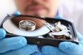 Male repairman wearing blue gloves is holding a hard drive Royalty Free Stock Photo