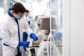 Male researcher checking test tubes while using research machine Royalty Free Stock Photo