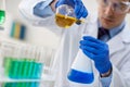 Male researcher examining flasks with different samples