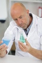 male researcher holding flask with blue liquid in lab Royalty Free Stock Photo