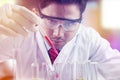 Male researcher pouring chemical fluid on test tube