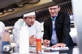 Male restaurant manager writing on clipboard while interacting to head chef