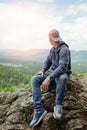 Male resting and enjoying the mountain sitting on rock Royalty Free Stock Photo