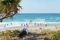 Male resting on sand in shade on pandanus tree with beach background Royalty Free Stock Photo