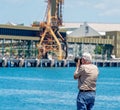 Male Retiree Hobby Photographer At An Industrial Wharf