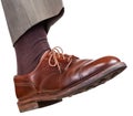 Male right foot in brown shoe takes a step