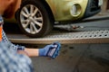 Male road worker monitoring car loading process