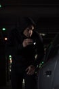 male robber in black hoodie with flashlight looking into Royalty Free Stock Photo