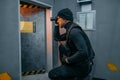 Male robber in black uniform holds gun and lantern Royalty Free Stock Photo