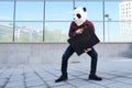 Male robber wearing a panda head mask stealing a briefcase escaping and looking back