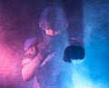 Male robot cop waves and punches his fits in dark. Halfman is ready for fight. Bionic cyborg looks at camera. Red blue light. Law Royalty Free Stock Photo