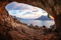 Male rock climber climbing along a roof in a cave