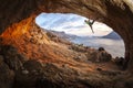 Male rock climber climbing along a roof in a cave