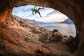 Male rock climber climbing along a roof in a cave