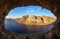 Male rock climber climbing along roof in cave before sunset. Royalty Free Stock Photo