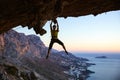 Male rock climber gripping handhold on ceiling in cave Royalty Free Stock Photo