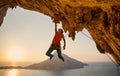 Male rock climber hanging with one hand on challenging route on cliff Royalty Free Stock Photo