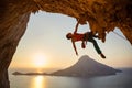 Male rock climber hanging with one hand on challenging route on cliff Royalty Free Stock Photo