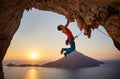 Male rock climber hanging with one hand on challenging route on cliff Royalty Free Stock Photo