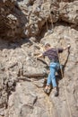 Rock climber in New Mexico attached to rock, climbing up canyon wall