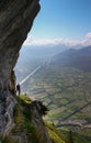 Male rock climber on a steep and exposed rock band on his way to a climbing route with a great view of the mountain landscape behi Royalty Free Stock Photo