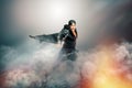 Male rock singer with cape in mysterious scenery with smoke
