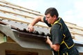 Male roofer fitting tiles