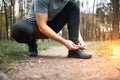 Man tying sneakers. Male runner jogging at the park. Guy training outdoors. Exercising on forest path. Healthy, fitness, wellness Royalty Free Stock Photo