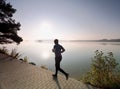 Male runner exercising on footpath at coast of island