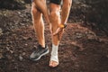 Male runner holding injured bandaging leg close-up