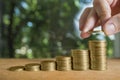 Male`s hand put coin stack on money staircase. Business growing and saving money concept Royalty Free Stock Photo