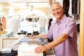 Male Sales Assistant At Checkout Of Clothing Store Royalty Free Stock Photo