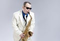 Male Saxophone Player Performing On Alto Saxo In White Suit and Sunglasses Against White