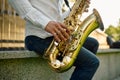 Male saxophonist plays the saxophone in park